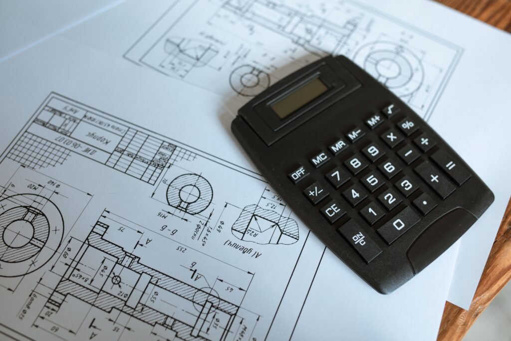 A calculator resting on construction blueprints for project cost planning