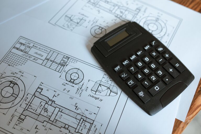 A calculator resting on construction blueprints for project cost planning