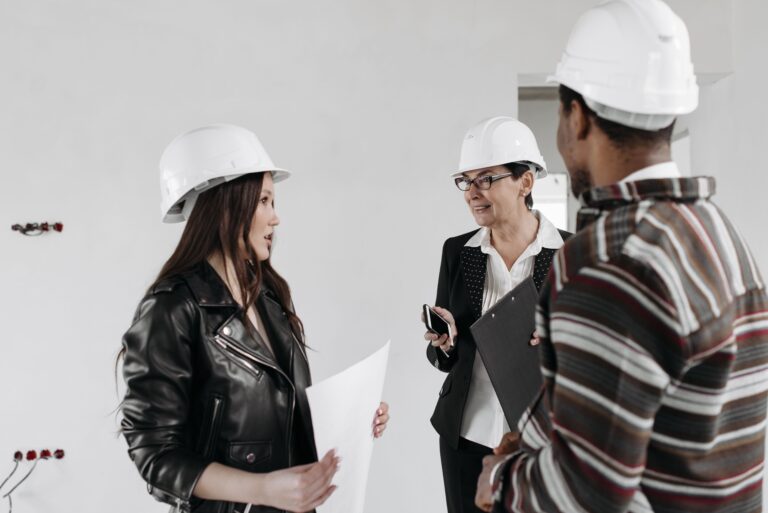 Construction professionals reviewing project plans inside an unfinished building
